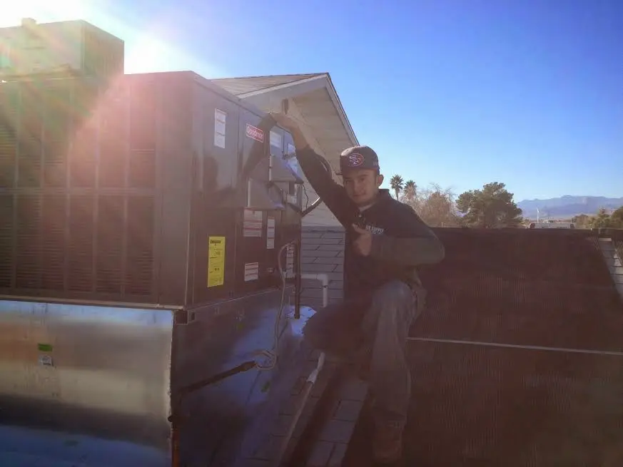 HVAC technician performing Heat Pump Repair on a rooftop unit in Wausau