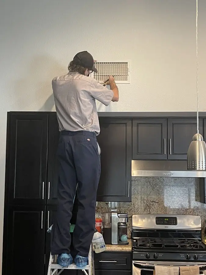Technician inspecting an air vent during HVAC service in Wausau